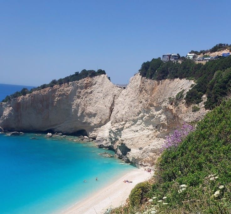 A quiet coastal cove in Greece, with turquoise water and pale cliffs